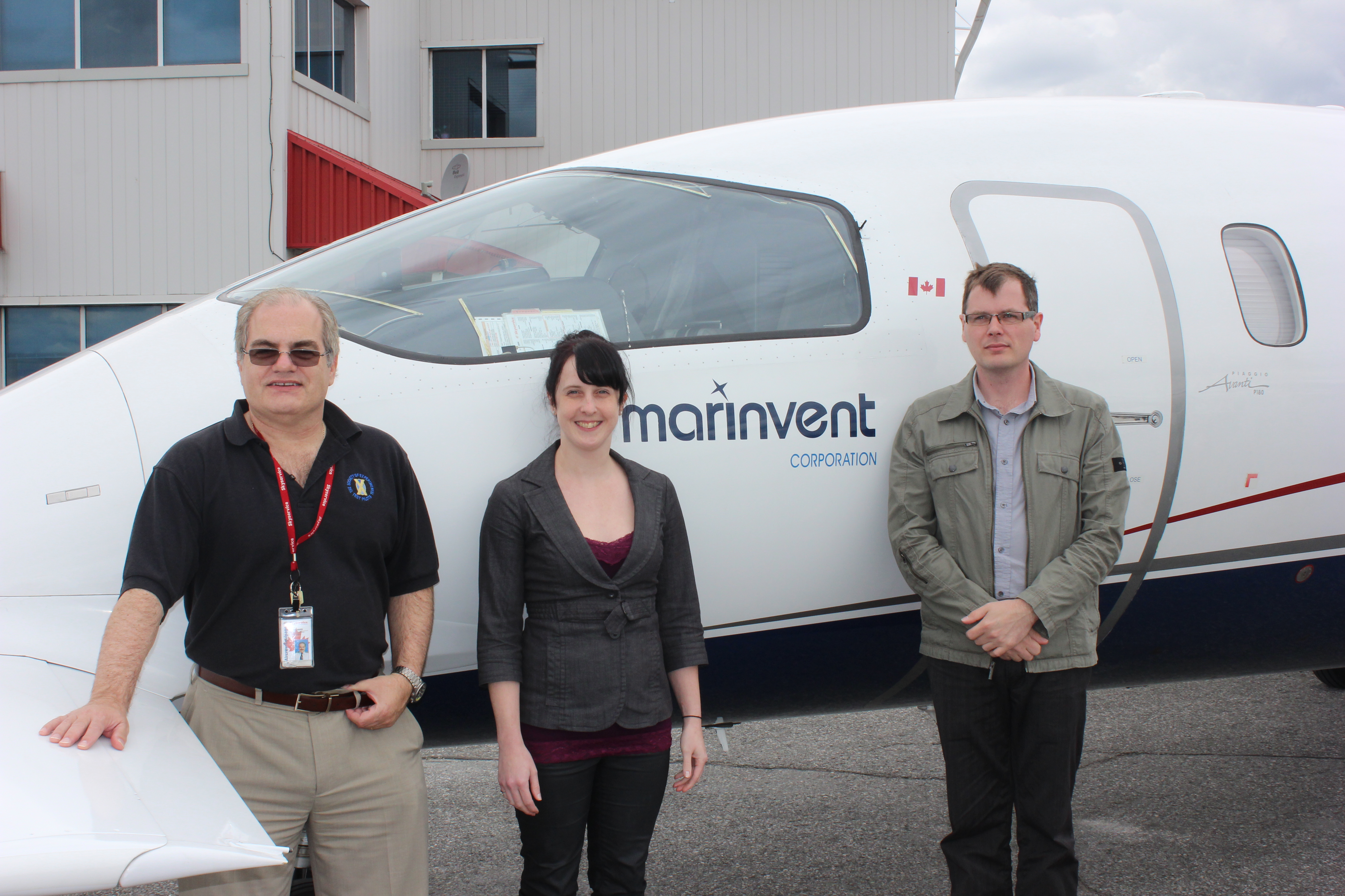 Maris and his team in front of the company's signature Plaggio, P-180  Avanti avionics test bed aircraft